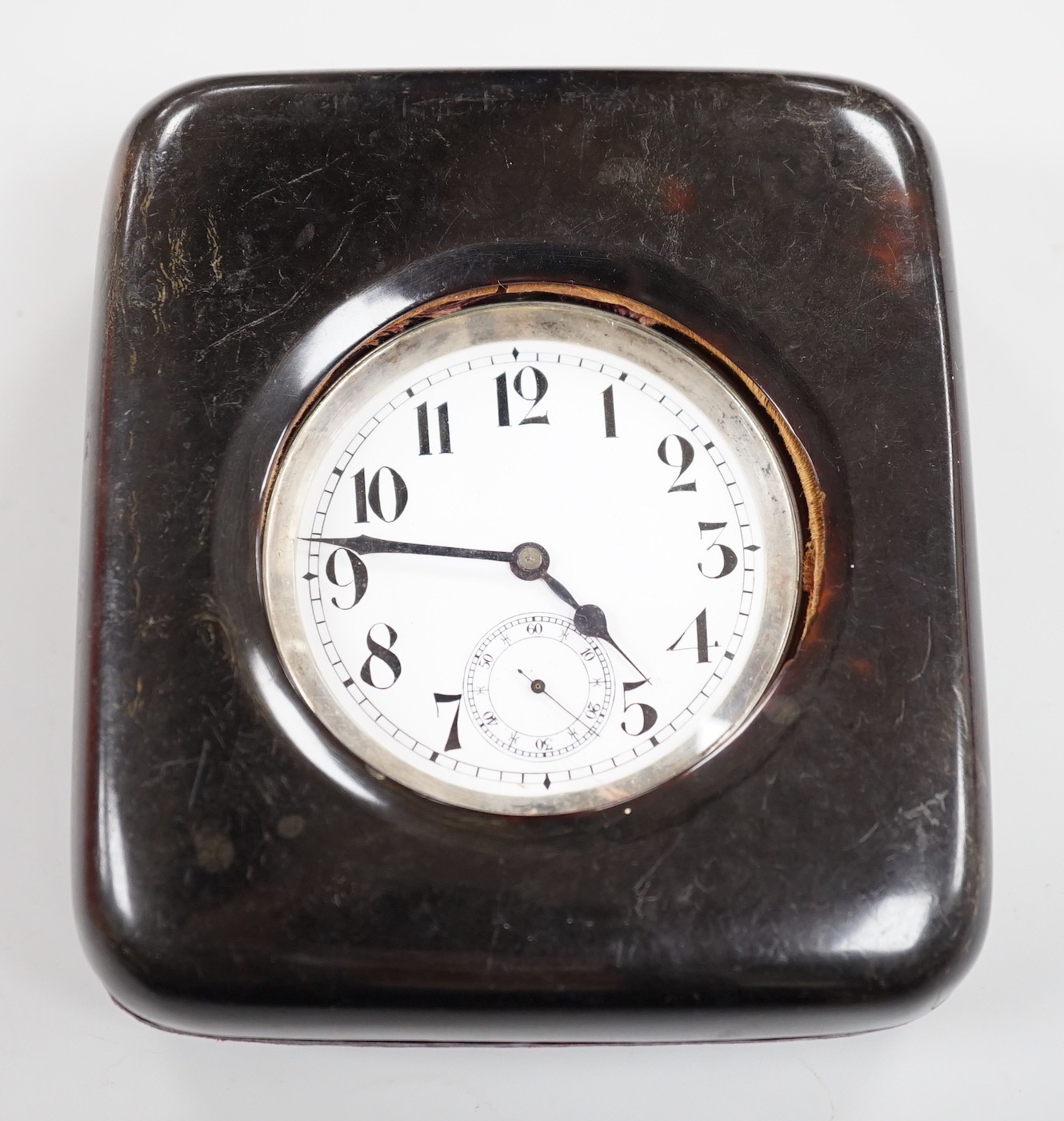 A tortoiseshell mounted travelling watch case, containing a Swiss white metal pocket watch, case diameter 67mm, outer case 11.5cm.